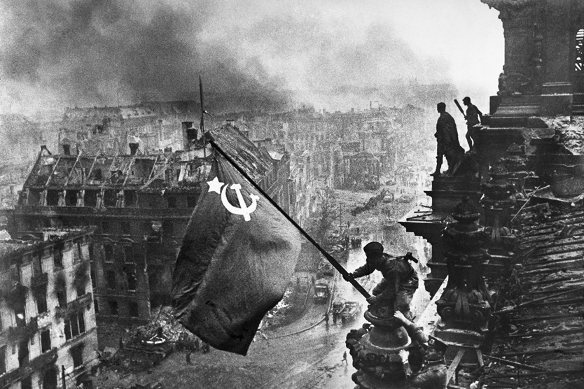 Алексей Ковалев и Абдулхаким Исмаилов с красным знаменем на крыше здания Рейхстага