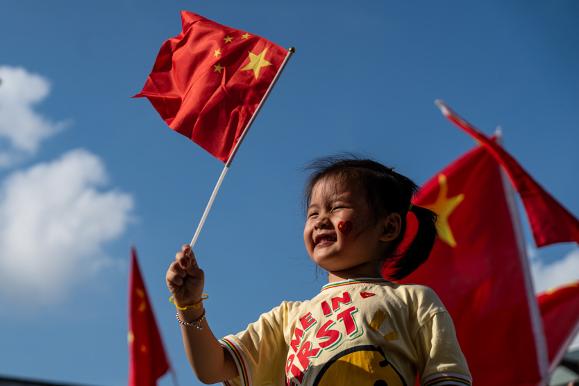 Китайская девочка держит национальный флаг КНР
