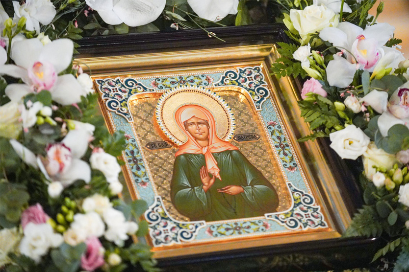 Икона Матроны Московской окружена цветами.