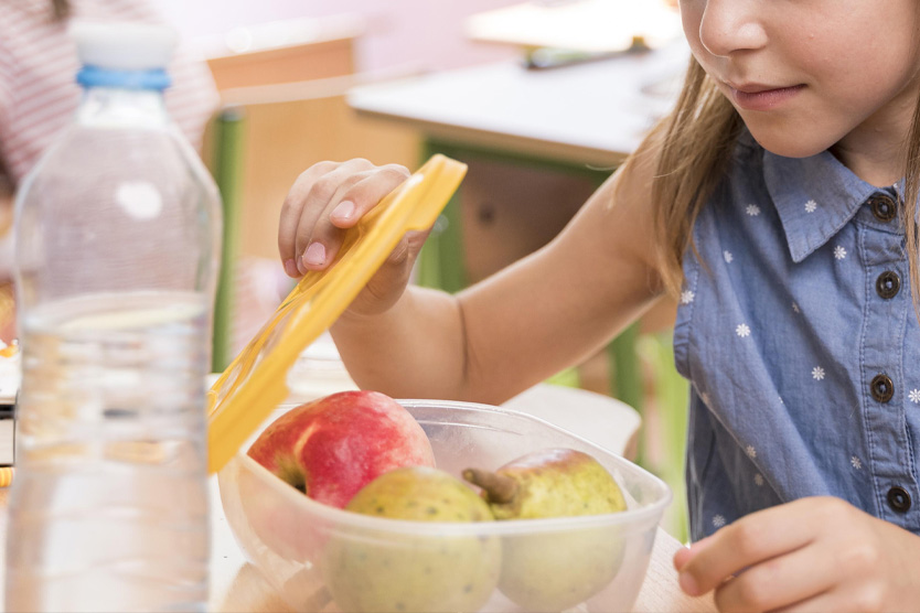 Девочка открывает контейнер с едой