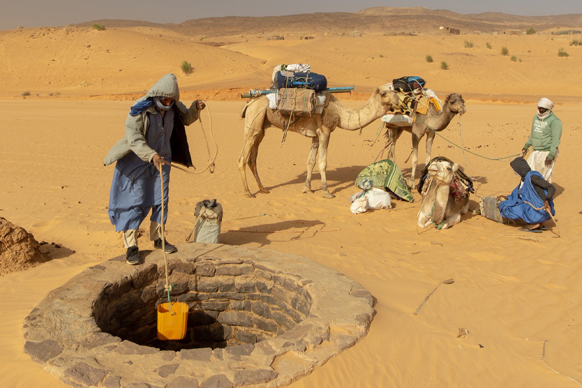 Мужчина набирает воду из колодца Тиминит в Мавритании